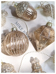 Detail of champagne gold Christmas ornaments with vertical stripes and glitter texture