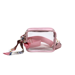 Detailed view of pink clear PVC crossbody bag with wide strap and silk scarf decoration