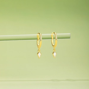 Macro detail of S925 hallmark on a gold-plated kite-shaped zircon hoop earring