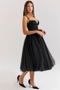 Detail of elegant black tulle evening dress with slim straps and sheer mesh texture