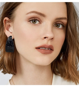 Macro detail of high-quality black marble pattern resin hoop earring on a model