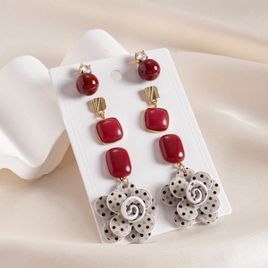 Set of 6 acrylic earrings with red flowers and vintage geometric studs on silk background