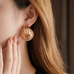 Retro hollow metal mesh earrings in vintage gold finish for women on model