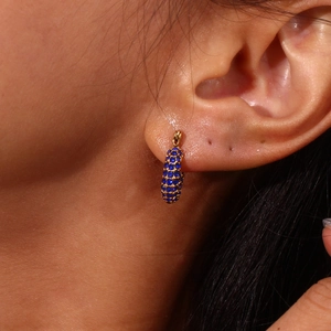 Macro view of gold stainless steel hoop earrings with micro-paved blue zircons