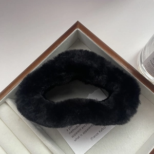 Close-up of black plush cloud-shaped hair claw clip with soft faux fur texture