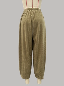 Detail van olijfgroene corduroy broek met elastische tailleband en wijde pijpen