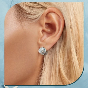 Detailed view of sterling silver shell earrings with light blue starfish enamel accents