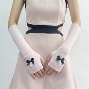 Pink JK style arm warmers with black ribbon bows and pearl charms for Lolita fashion