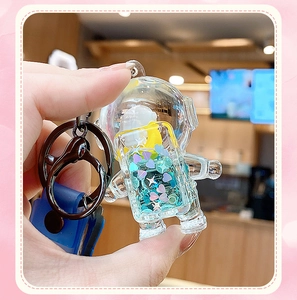 Close-up of astronaut liquid sand keychain with blue silicone strap and metal ring