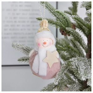Pink plush snowman ornament with white scarf and gold-trimmed hat on a snowy pine tree