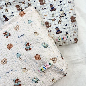 Detail of quilted cotton fabric texture with cartoon bear and puppy embroidery patterns