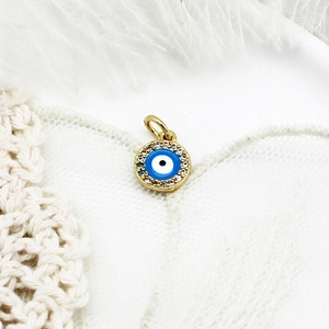 Macro view of evil eye jewelry pendant with blue enamel and sparkling crystals