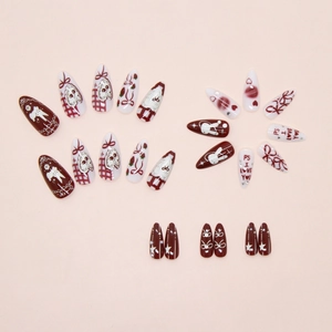 Detail of red and white almond nails featuring bunny, strawberry, and bow designs