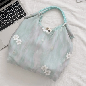 Detailed close-up of mint green tie-dye tote with 3D floral lace and woven handles