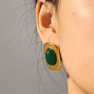 Gros plan de boucles d'oreilles vintage en or 18k avec pierre cabochon vert émeraude