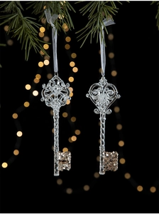 Detail of crystal clear acrylic Christmas keys with gold glitter on pine branches
