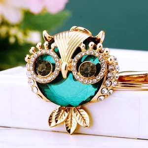 Detailed view of owl keychain with large green faceted gemstone and sparkling rhinestones