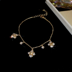 Detail of gold flower bracelet with zircon stones on a black background closeup