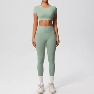Détail d'un ensemble de yoga vert avec haut court à manches courtes et legging taille haute