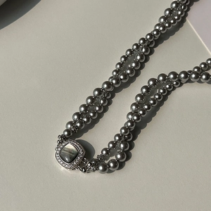 Detail of double-layer gray pearl necklace with vintage square zircon-set clasp