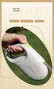 Close-up of retractable dog leash with light green brake button and woven nylon cord