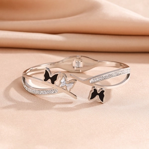 Macro shot of silver titanium bangle featuring black and white zircon butterfly charms