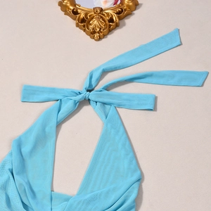 Close-up of light blue mesh halter top with knot tie detail on a textured background