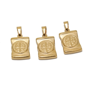 Macro detail of three golden square Saint Benedict medal pendants for necklaces