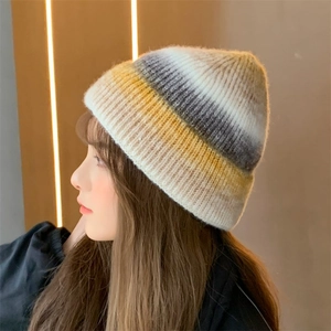 Detailed side view of a yellow and grey gradient tie-dye knitted beanie on a female model