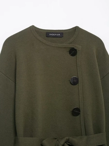 Detailansicht der dunkelgrünen Strickjacke mit schwarzen Knöpfen und Taillengürtel