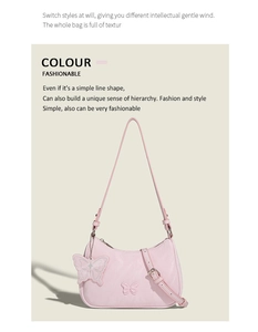 Close-up of pink shoulder bag with butterfly embossed pattern and matching charm