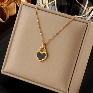 Macro shot of 18K gold heart-shaped padlock necklace with black inlay in jewelry box