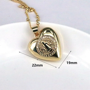 Detail of 22mm gold heart pendant with St. Benedict medal and white CZ crystals