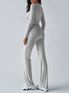 Side view of woman in Y2K grey slim long sleeve crop top and flared pants set