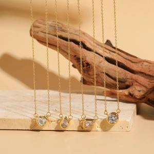 Macro view of gold necklaces featuring heart, drop, and geometric cubic zirconia pendants