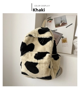 Detail of khaki cow print plush backpack featuring soft faux fur and durable zipper