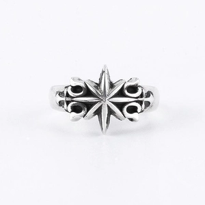 Macro shot of silver vintage star cross ring showing retro textured finish on white background