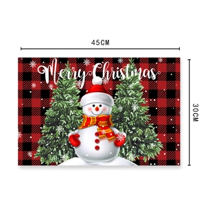 Christmas place mat featuring red buffalo plaid pattern with snowman and trees