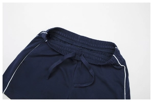 Détail du short de sport bleu marine avec taille élastique, cordons et rayures blanches