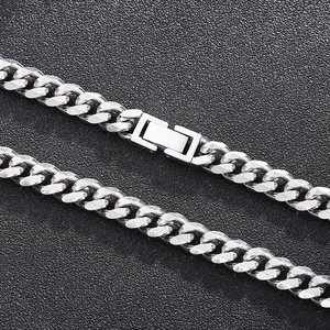 Macro detail of silver stainless steel Cuban link necklace with unique rectangle buckle