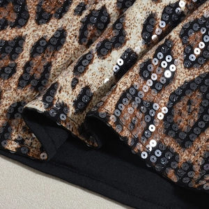 Gros plan sur tissu léopard avec paillettes brillantes et détails de bordure noire