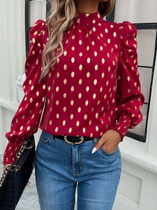 Detail of red women shirt with gold polka dots featuring puff sleeves and smocked cuffs