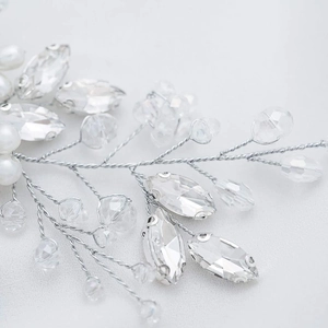 Macro shot of silver bridal headpiece featuring faceted crystals and white faux pearls