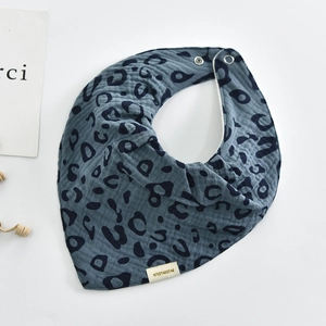Detailed view of gray-blue leopard print cotton baby bib with secure snap fasteners