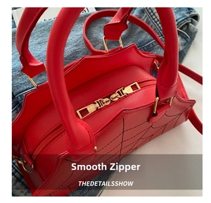 Macro shot of red shell bag with spiderweb stitching and golden dual zippers detail
