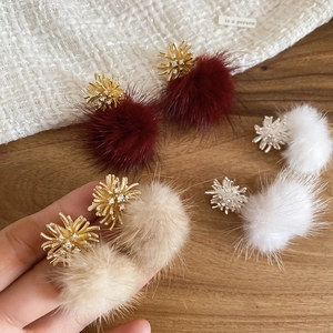 Detail showing burgundy pom-pom drop earrings with sparkling zirconia firework studs