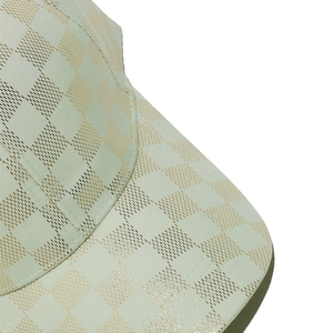 Detail of mint green baseball cap featuring gold metallic checkered pattern and stitching