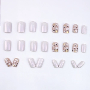 Short pearlescent white and hand-painted floral press-on nails set with gold leaf detail