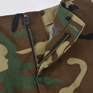 Makro-Detail des Camouflage-Rocks mit Reißverschluss und schwarzem Knopfverschluss