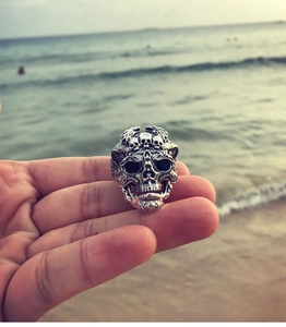 Gros plan d'une bague tête de mort en argent vintage avec gaufrage devant les vagues
